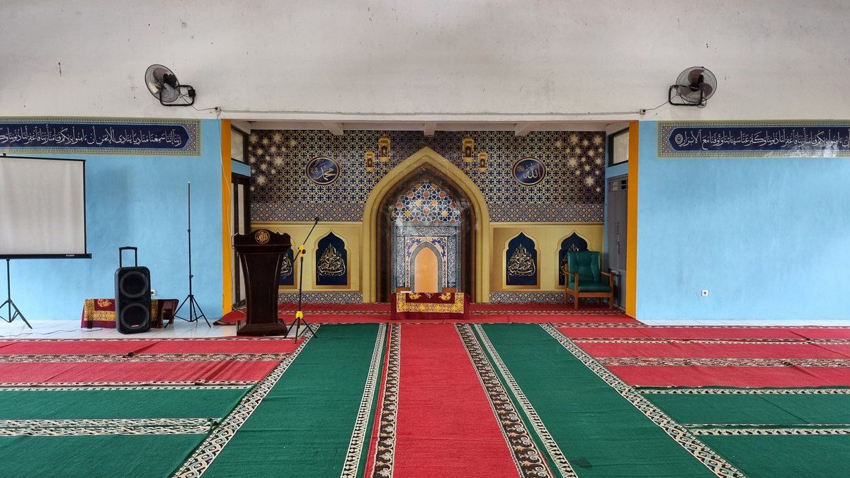 Ruang musholla dengan tempat shalat dan mimbar.