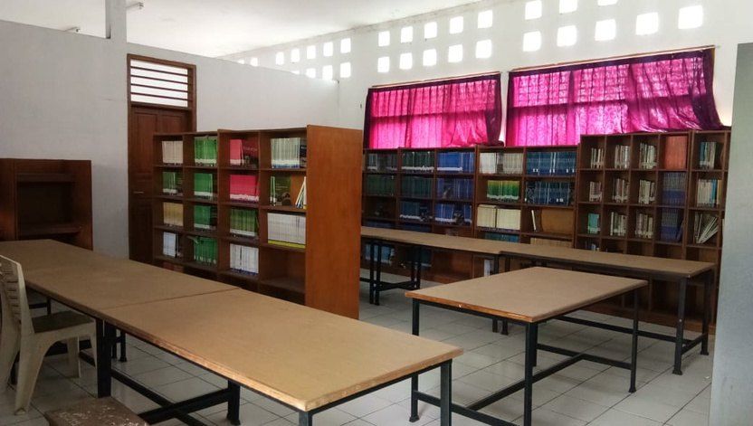 Rak buku dan meja baca di perpustakaan SMPIT.