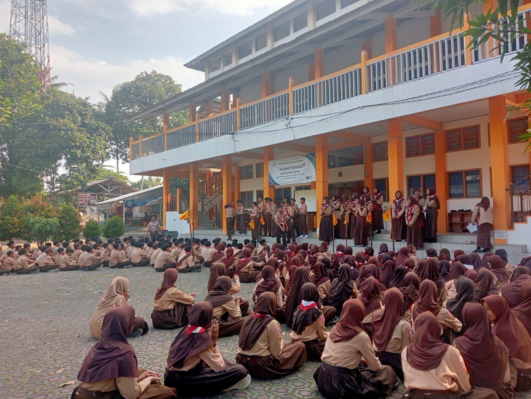 Siswa berkumpul dalam kegiatan Pramuka di lingkungan sekolah.